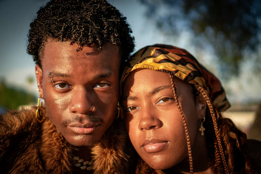 Close golden-hour festival portrait of two friends