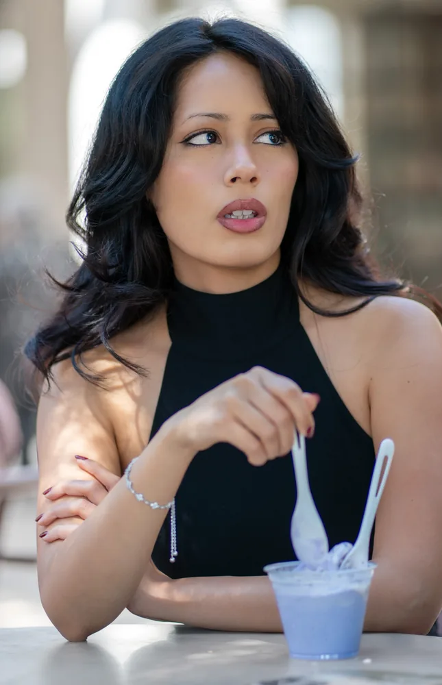 Candid outdoor portrait of a woman seated at a table