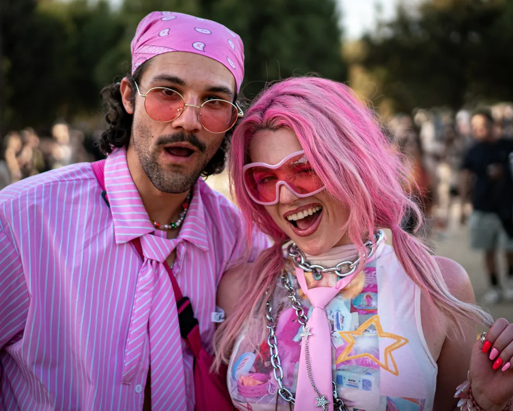 Playful festival portrait of two people dressed in pink